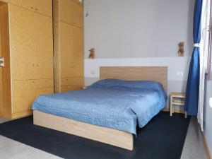 a bedroom with a bed with blue sheets and wooden cabinets at Venice Dose Suite in Venice