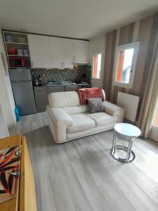 a living room with a white couch and a table at Maison avec sous sol indépendant et parking à 2km de Versailles in Buc