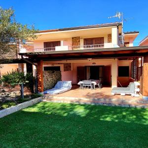 a house with a patio with a table and chairs at Villetta Eliselena Best Vacation Ever in Villasimius