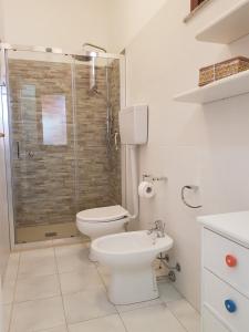 uma casa de banho com um WC e uma cabina de duche em vidro. em Villetta Eliselena Best Vacation Ever em Villasimius