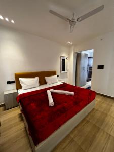 a bedroom with a large bed with a red blanket at The White House in Rishīkesh