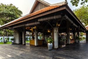 a restaurant with a large roof on a wooden deck at SOK VILLA by Angkorstays in Siem Reap