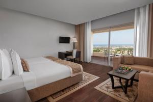 ein Hotelzimmer mit einem Bett und einem Wohnzimmer in der Unterkunft Steigenberger Makadi - Adults Friendly 16 Years Plus in Hurghada