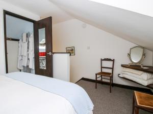 a bedroom with a bed and a mirror and a chair at The Wheelhouse in Church Stretton