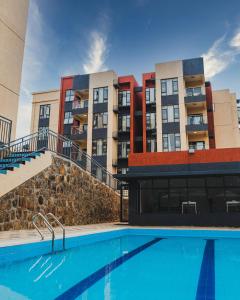 a swimming pool in front of a building at Rose Garden Private Apartment By LINK in Kigali