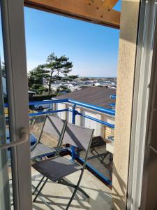 a chair on a balcony with a view of the ocean at Le Scottish in Camiers +2 photos