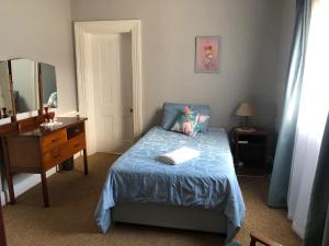 um quarto com uma cama, uma secretária e um espelho em Anne's Cottage 