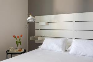 een slaapkamer met een wit bed met een wit hoofdeinde bij Nice home in Carini