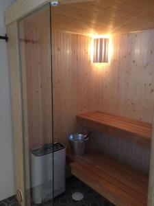 een houten sauna met een vuilnisbak en een lamp bij Björnrike Vemdalen. Mitt i backen in Vemdalen
