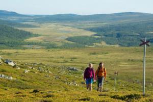 two women walking on a hill with a windmill at Björnrike Vemdalen. Mitt i backen in Vemdalen