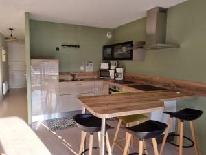 a kitchen with a wooden counter and stools at Le Scottish in Camiers