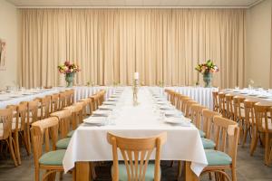a long table in a room with tables and chairs at Hotel Rozmaryn i Lawenda in Minikowo