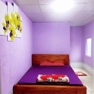 a purple bedroom with a bed in a room at Homestay Hải Nam Đất Mũi in Xóm Mũi