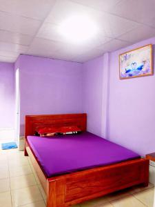 a bedroom with a purple bed in a room at Homestay Hải Nam Đất Mũi in Xóm Mũi