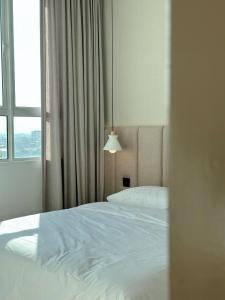 a bedroom with a white bed and a window at SAMUA Homes (City View, Drawbridge & KTCC Mall) in Kuala Terengganu