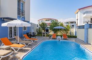 uma piscina com cadeiras e guarda-sóis ao lado de um edifício em Splendid Villa with Private Pool in Antalya em Belek