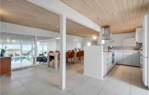 エーベルトフトにあるAmazing Home In Ebeltoft With 5 Bedrooms, Sauna And Indoor Swimming Poolのキッチン、海の景色を望むダイニングルーム