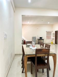 uma sala de jantar com mesa e cadeiras em The INN em Mysore