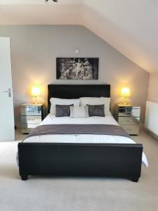 a large bedroom with a large bed with two lamps at Victoriana Apartment, Central - Boutique in Stratford-upon-Avon