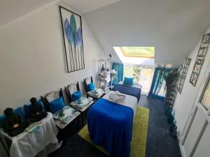 salon z niebieskimi stołami i kanapami w pokoju w obiekcie Maison Cosy en Pleine Nature 
