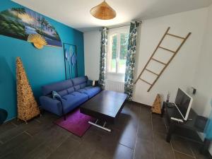 salon z niebieską kanapą i stołem w obiekcie Maison Cosy en Pleine Nature 