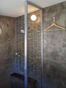 La salle de bains est pourvue d'une douche avec une porte en verre. dans l'établissement 　Komori Village GH ～小森ヴィレッジ ゲストハウス～ 自然の中にある庭付平屋一棟貸, 