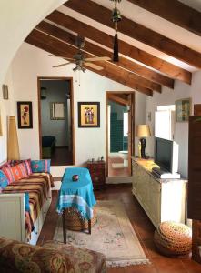 een woonkamer met een bank en een tv bij Casa Ganesha in Comares