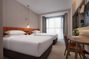 Tempat tidur dalam kamar di Home2 Suites By Hilton Wuhan Hankou Railway Station
