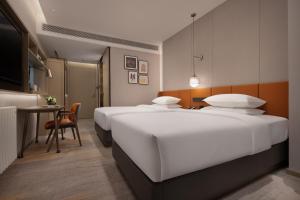 Tempat tidur dalam kamar di Home2 Suites By Hilton Wuhan Hankou Railway Station