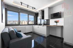 sala de estar con sofá y cocina con ventanas en Calliope Penthouse, Nilie Hospitality MGMT en Tesalónica
