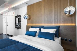 - une chambre dotée d'un grand lit avec des oreillers bleus et blancs dans l'établissement Calliope Penthouse, Nilie Hospitality MGMT, à Thessalonique