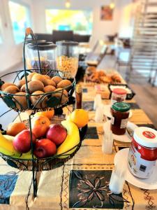 a table topped with baskets of fruit and other foods at Hôtel Land'Azur in Mimizan-Plage