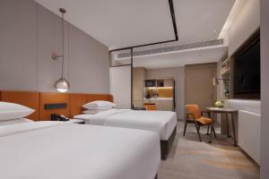Tempat tidur dalam kamar di Home2 Suites By Hilton Wuhan Hankou Railway Station
