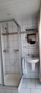 a bathroom with a shower and a sink at Gästehaus Föhr in Wintrich