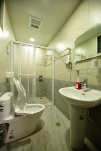 y baño con aseo, lavabo y ducha. en 東引海悅樓民宿, en Dongyin/