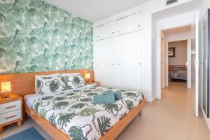 a bedroom with a bed with a green wall at Mar i Llum in Platja  d'Aro +12 photos