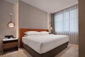 Tempat tidur dalam kamar di Home2 Suites By Hilton Wuhan Hankou Railway Station