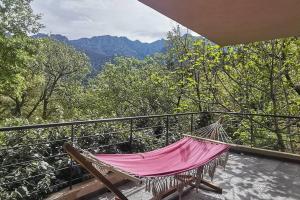 uma rede de descanso numa varanda com vista para as montanhas em Maison avec jacuzzi au cœur des montagnes em Feliceto