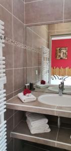 a bathroom with a sink and a mirror and towels at Maison avec jacuzzi au cœur des montagnes in Feliceto