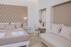 a bedroom with two beds and a desk at Dora Apartments in Agia Pelagia