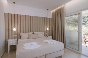 a bedroom with a bed with two white towels on it at Dora Apartments in Agia Pelagia