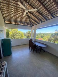a dining room with a table and chairs and a large window at sunny mound unawatuna close by sri yoga shala in Unawatuna