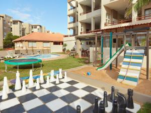 un tablero de ajedrez frente a un edificio con piscina en First Group Costa Smeralda, en Margate