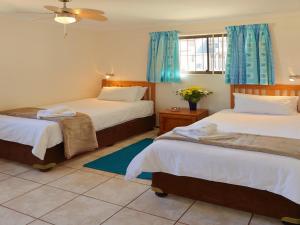 a bedroom with two beds with blue curtains at First Group Costa Smeralda in Margate