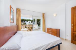 a bedroom with a large bed and a balcony at Apto con Terraza 6 in Paguera