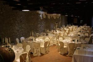 una grande sala banchetti con tavoli e sedie bianchi di Villa Chiopris a Chiópris-Viscone