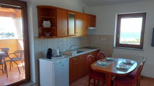 eine Küche mit einem kleinen Tisch und einem weißen Kühlschrank in der Unterkunft WineHouse with Seaview Gregoric in Izola