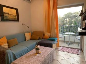 a living room with a blue couch and a balcony at Hotel Villa Anais in Prinos