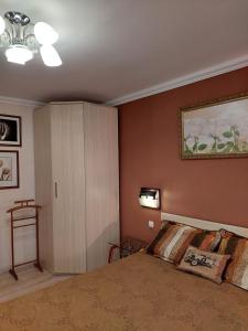 a bedroom with a large bed and a cabinet at Apartments on Kharkovskaya Street in Sumy