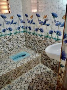 uma casa de banho com flores azuis na parede em Harbour town holiday home -malpe em Malpe